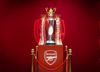 Il trofeo della Premier League esposto insieme allo stemma dell’Arsenal.