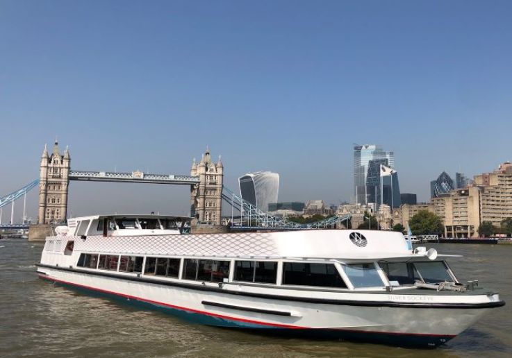Il Silver Sockeye, battello da crociera bianco, sul Tamigi davanti al Tower Bridge, di giorno