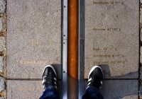 Visitatori con i piedi ai due lati del Meridiano Zero di Greenwich.