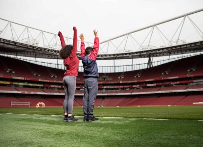 Due visitatori scoprono il terreno di gioco durante il tour dello stadio dell’Arsenal.