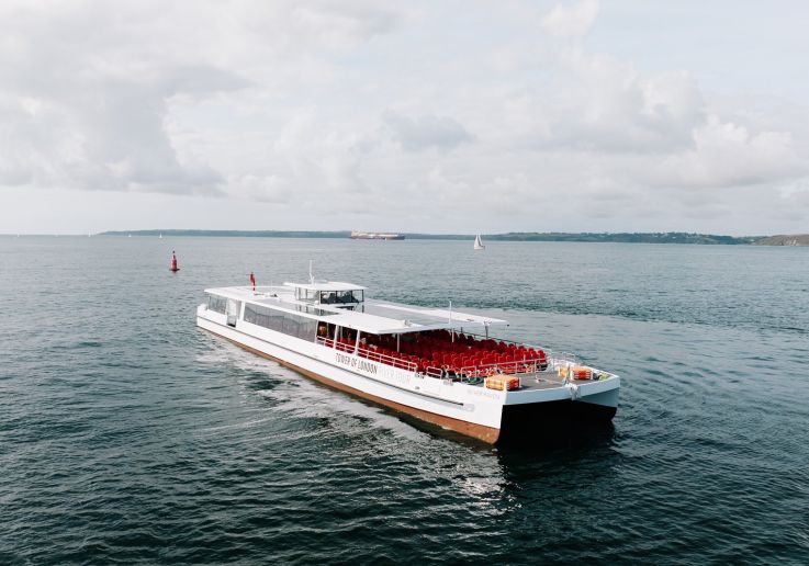 Il Silver Raven, barca elettrica bianca con un ponte scoperto a sedili rossi, in navigazione di giorno