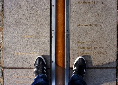 Visitatori con i piedi ai due lati del Meridiano Zero di Greenwich.
