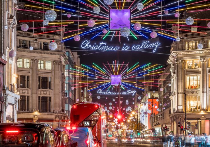Decorazioni luminose multicolori e autobus rossi nelle strade del centro di Londra.