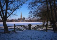 Vista della Cattedrale di Salisbury attraverso il parco ricoperto di neve.