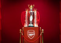 Il trofeo della Premier League esposto insieme allo stemma dell’Arsenal.