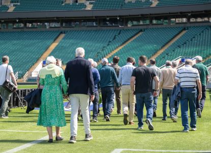 Un gruppo di visitatori scopre il terreno di gioco durante il tour dello stadio.