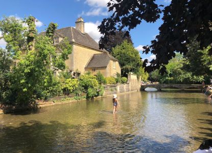 Tipico cottage inglese e ruscello nelle Cotswolds
