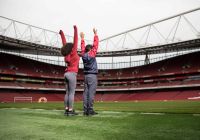 Due visitatori scoprono il terreno di gioco durante il tour dello stadio dell’Arsenal.