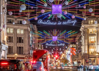 Decorazioni luminose multicolori e autobus rossi nelle strade del centro di Londra.