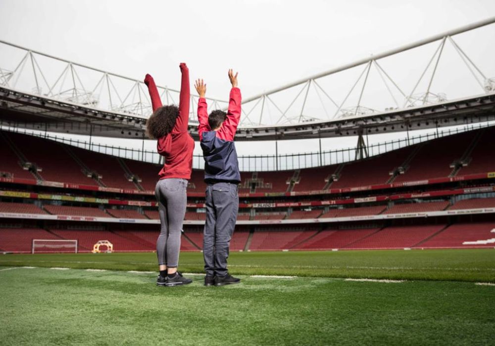 Due visitatori scoprono il terreno di gioco durante il tour dello stadio dell’Arsenal.