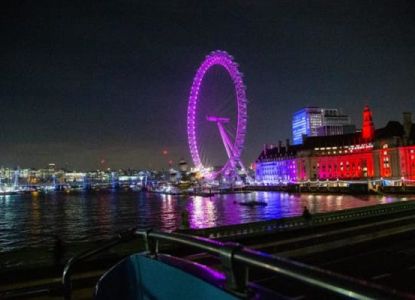 London Eye illuminata di notte sul Tamigi